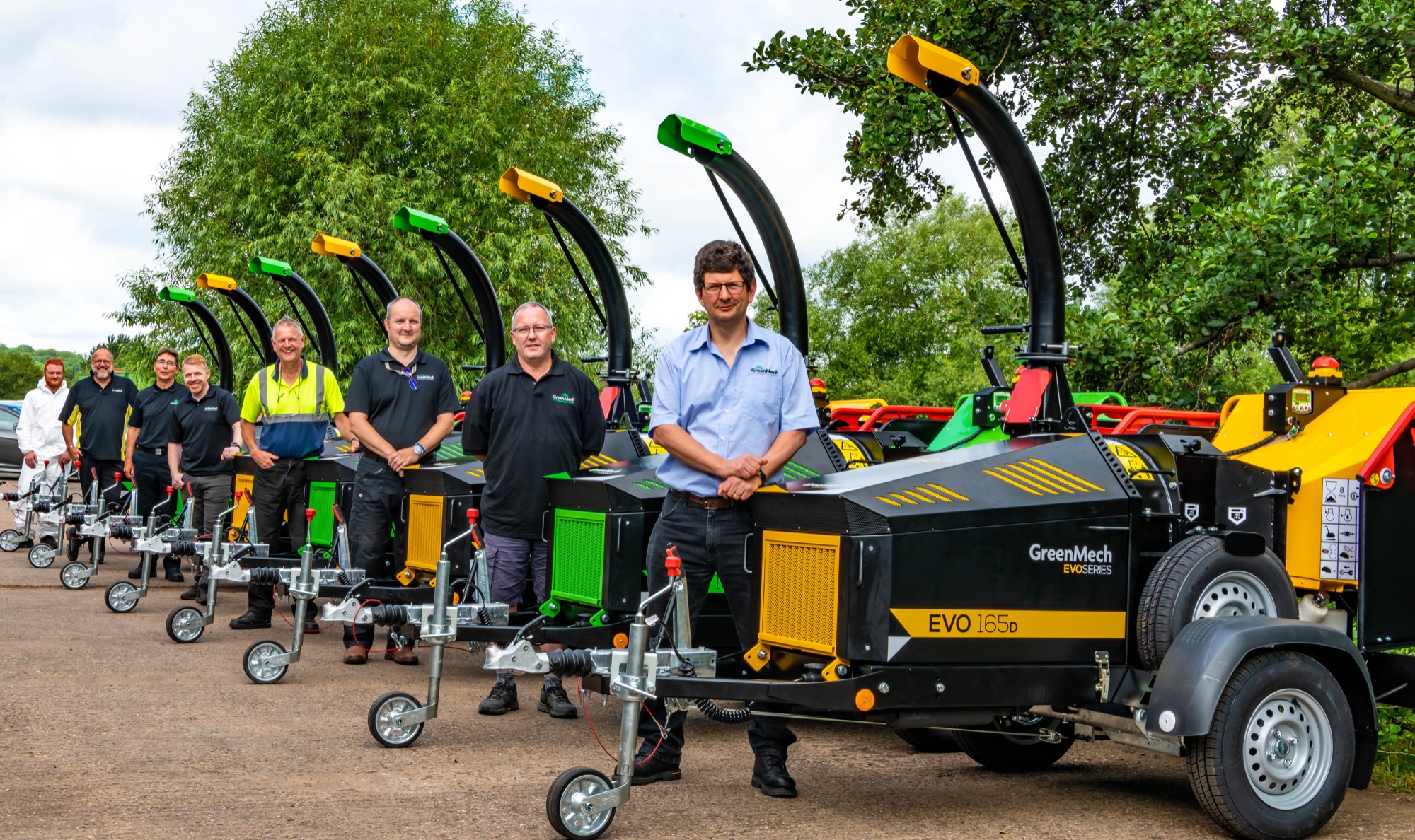 GreenMech-About-Us GreenMech members of staff stood next to Woodchippers in Alcester where they are manufactured